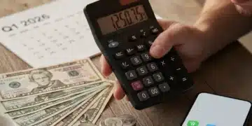 Hand using calculator with US dollars, symbolizing smart budgeting amidst inflation in 2026